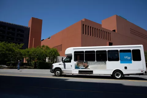 UCSF shuttle driving North on Owens Street, with the Rutter Center in the background, at Mission Bay.